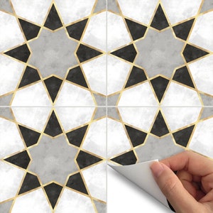 May include: Four peel-and-stick tile decals featuring a geometric pattern of black and gold stars on a white and gray background.