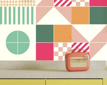 May include: A retro-style radio with a cream-colored body and a red dial sits on a yellow countertop with a geometric pattern of pink, green, and orange tiles behind it.