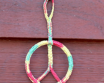 Adorno colgante con el símbolo de la paz en cáñamo macramé teñido anudado.