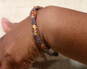 Tobillera o pulsera de macramé marrón oscuro con cuentas de madera pintadas multicolores, longitud ajustable.