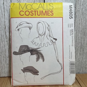 May include: A McCall's Costumes sewing pattern envelope M4805 for sizes small, medium, and large. The front features illustrations of various headwear including a beret, a feathered hat, and a hooded cowl with a long tail and scalloped edges.
