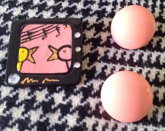 Pink and black ceramic pin ducks singing on TV with pink ceramic earrings