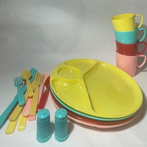 May include: A set of colorful plastic children's dishes, including a divided plate, cups, and utensils. The set is in shades of yellow, pink, red, blue, and turquoise.