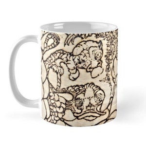 Peut inclure: Une tasse en céramique blanche avec un motif noir et blanc de poissons stylisés. Les poissons sont dessinés dans un style détaillé et complexe.