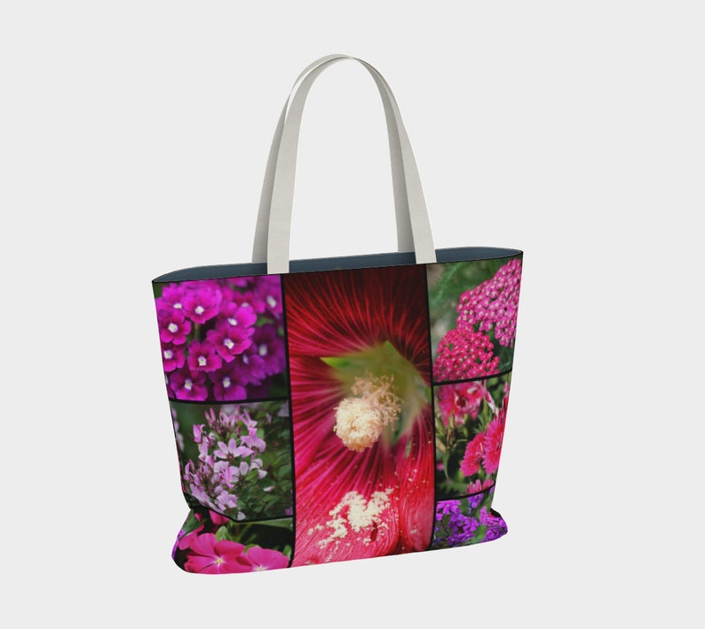 May include: A tote bag with a collage of pink, purple, and red flowers. The bag has white straps and a dark blue lining.