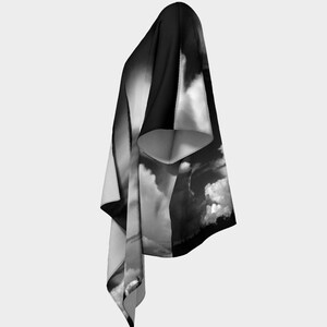 May include: A black and white kimono with a dramatic cloud print. The kimono has a long, flowing silhouette and a wide, open neckline.