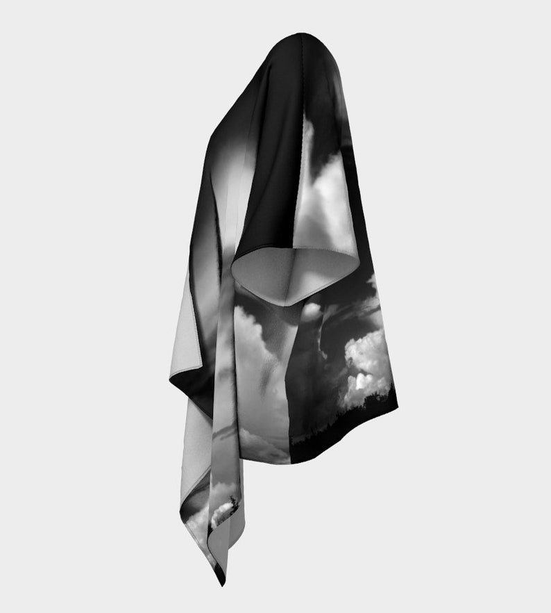 May include: A black and white kimono with a dramatic cloud print. The kimono has a long, flowing silhouette and a wide, open neckline.