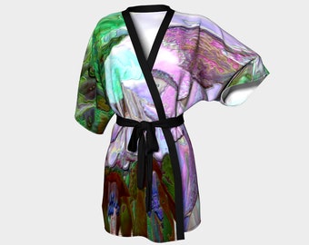 Puede incluir: Una bata colorida con una faja negra y un patrón abstracto en espiral en tonos de verde, morado, rosa y azul.