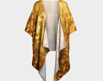 Puede incluir: Un kimono dorado y blanco con un patrón floral. El kimono está hecho de una tela ligera y tiene una silueta fluida.