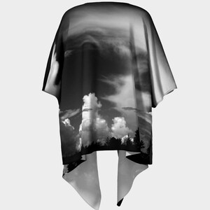May include: Black and white kimono with a dramatic sky and clouds print. The kimono has a wide, flowing silhouette and a long, flowing hem.