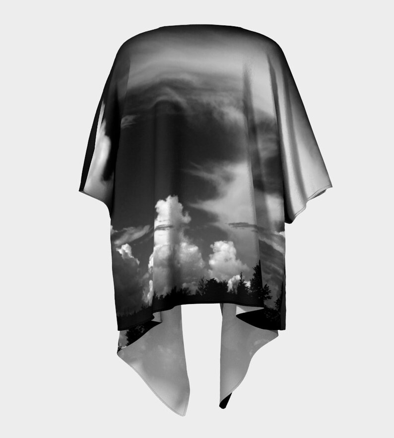 May include: Black and white kimono with a dramatic sky and clouds print. The kimono has a wide, flowing silhouette and a long, flowing hem.