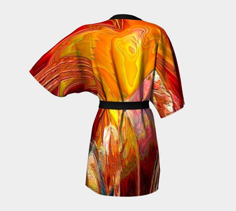 Puede incluir: Una bata de kimono de estampado abstracto rojo, naranja y amarillo con una faja negra.