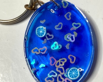 Blue citrus handmade resin keychain, oval with more citrus slices and iridescent hearts