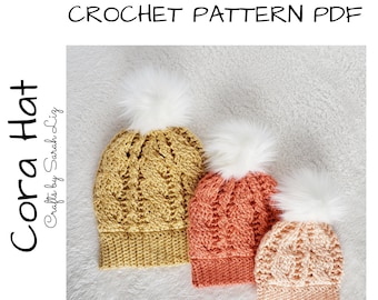 May include: Three crocheted hats in different sizes with white pom-poms. The hats are in shades of yellow, orange, and pink. The hats are on a white fuzzy surface. The text "Cora Hat Crafts by Sarah Liz" is in the image.