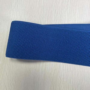 May include: A close-up of a blue elastic band with a textured surface.