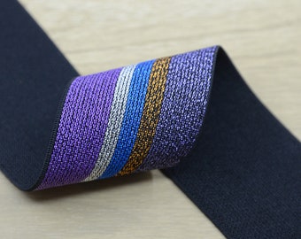 Puede incluir: Banda elástica negra con una franja de purpurina morada, azul, plateada y dorada.