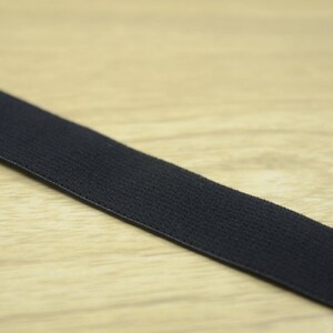 K&ouml;nnte beinhalten: Schwarzes Gummiband, eine Art Stoff, der zum N&auml;hen und Basteln verwendet wird.