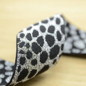 以下が含まれることがあります： レオパード柄の黒と銀のゴムバンド