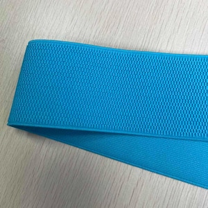 May include: A close-up of a bright blue elastic band with a textured surface.