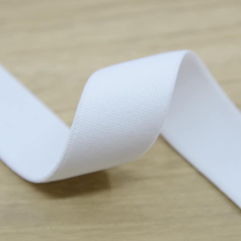 K&ouml;nnte beinhalten: Wei&szlig;es Gummiband, Nahaufnahme des weichen, strukturierten Stoffes.