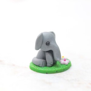 Miniatur Elefant aus Polymerclay, sitzend auf grünem Untergrund, Seitenansicht