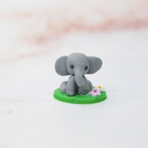 Miniatur Elefant aus Polymerclay, sitzend auf grünem Untergrund