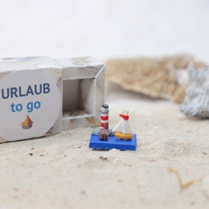 Holiday to go, travel for your pocket, holiday to go, lighthouse miniature, small sailing boat, holiday decoration
