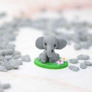 Miniatur Elefant aus Polymerclay, sitzend auf grünem Untergrund
