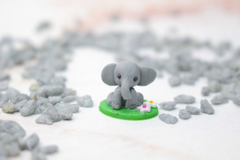 Miniatur Elefant aus Polymerclay, sitzend auf grünem Untergrund