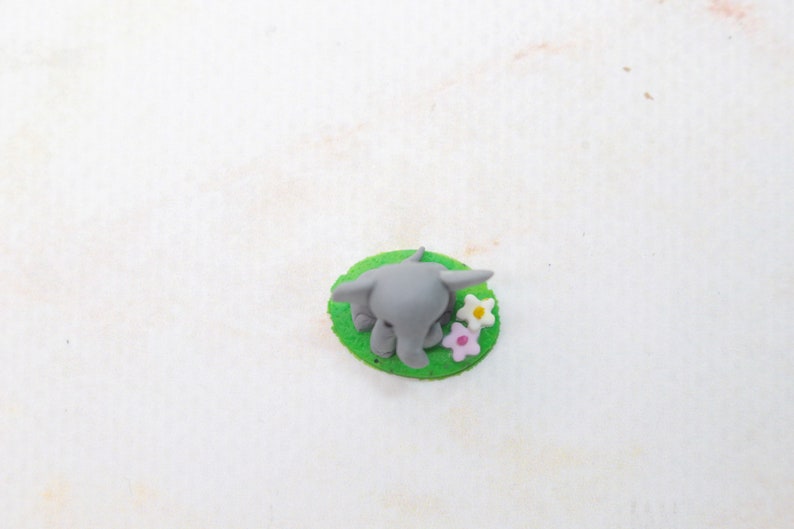 Miniatur Elefant aus Polymerclay, sitzend auf grünem Untergrund von oben