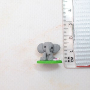 Miniatur Elefant aus Polymerclay, sitzend auf grünem Untergrund Vergleich mit cm Mass