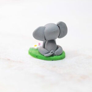 Miniatur Elefant aus Polymerclay, sitzend auf grünem Untergrund Ansicht von hinten