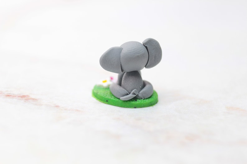 Miniatur Elefant aus Polymerclay, sitzend auf grünem Untergrund Ansicht von hinten