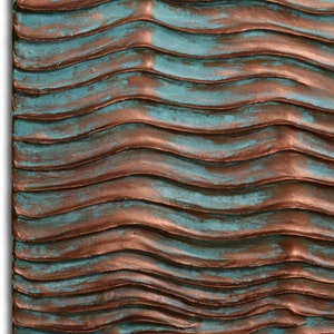 Puede incluir: Una pieza de arte de pared texturizada con un patr&oacute;n ondulado en tonos de turquesa y cobre.