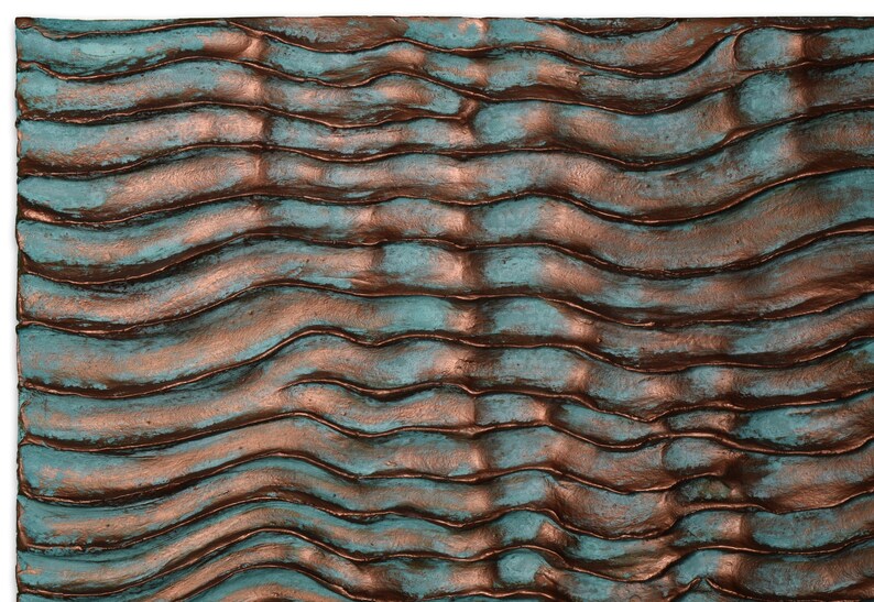 Puede incluir: Arte de pared abstracto con una superficie texturizada. La superficie est&aacute; pintada en tonos de turquesa y cobre, creando un patr&oacute;n ondulado.