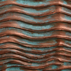 Puede incluir: Una pared texturizada con un patr&oacute;n ondulado pintado en tonos de turquesa y cobre.