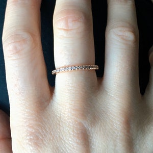 Peut inclure: Une délicate bague en or rose avec une rangée de petits diamants clairs.