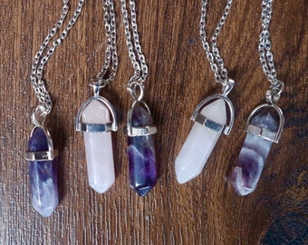 Puede incluir: Cinco collares de cadena plateada con colgantes de punta de cristal. Dos colgantes son de cuarzo transparente y tres son de amatista.