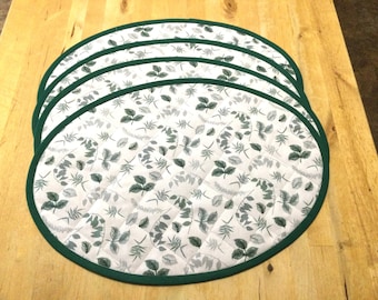 Oval placemats in leaves on white, green backing, quilted, and washable