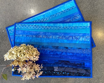 Blue quilted place mats will add memories of open sky and the warmth of the beach to your dining room or kitchen. Two washable table mats.