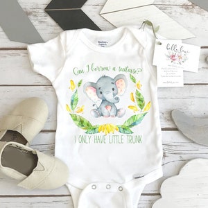 May include: White baby onesie with a watercolor illustration of a gray elephant with pink ears and a yellow flower crown. The onesie has the text "Can I borrow a suitcase? I only have little trunk."