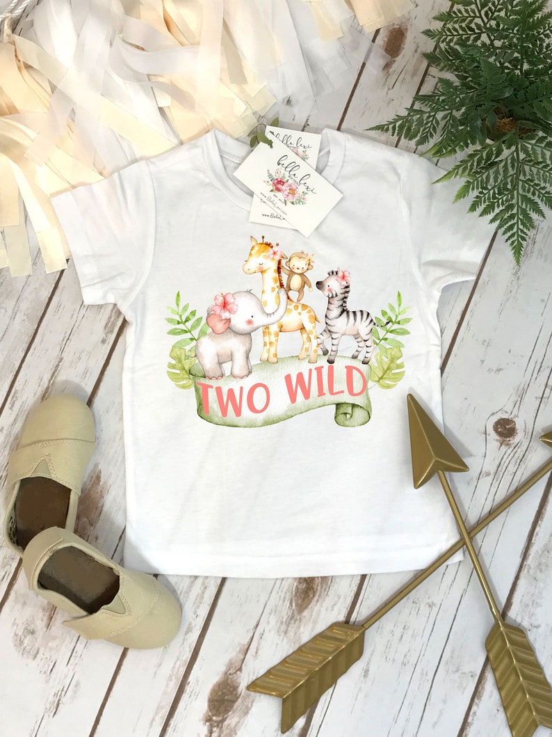 May include: White t-shirt with a graphic of a giraffe, elephant, monkey, and zebra with the text "Two Wild" on a green banner.