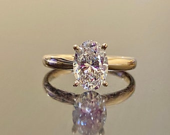 May include: A gold engagement ring with a large oval-shaped diamond.