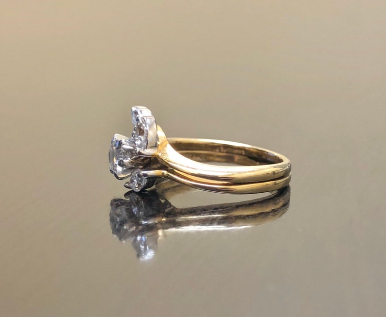 May include: A gold wedding band set with a diamond cluster ring. The cluster ring features a central diamond surrounded by smaller diamonds.