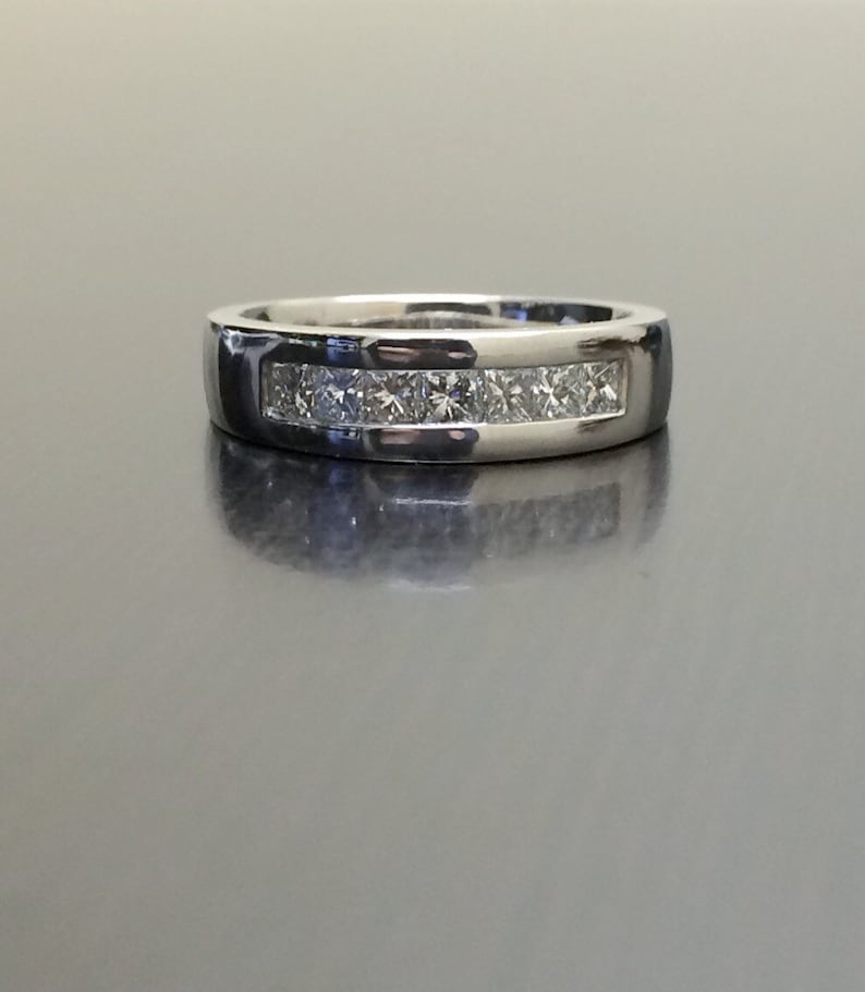 K&ouml;nnte beinhalten: Ein silberner Ring mit einer Reihe kleiner, klarer Diamanten, die in einer Kanalfassung gefasst sind.