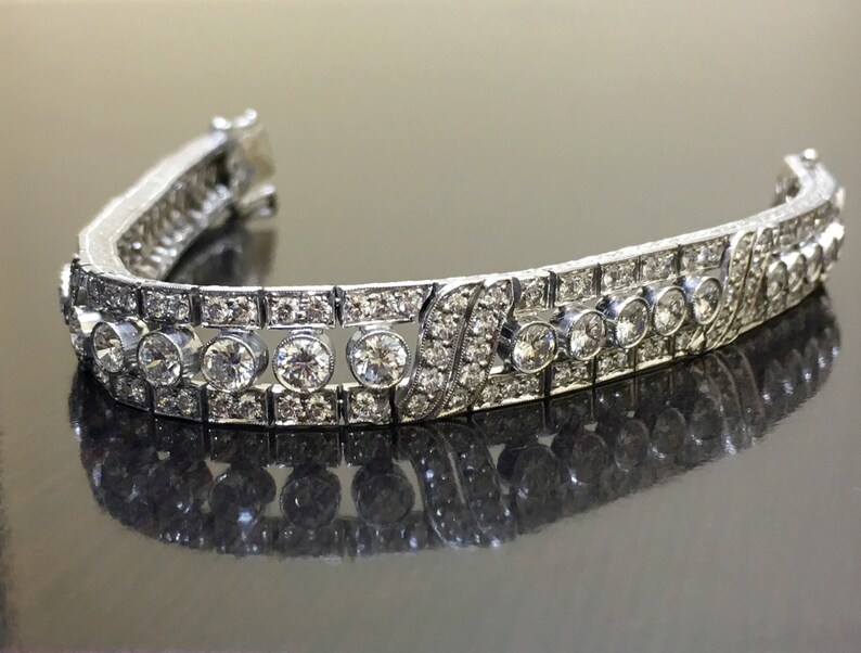 Puede incluir: Una pulsera de plata con una fila de diamantes redondos y una fila de diamantes cuadrados m&aacute;s peque&ntilde;os.