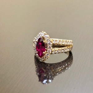 May include: A gold ring with a large, marquise-shaped ruby surrounded by a halo of smaller diamonds. The band is also set with diamonds.