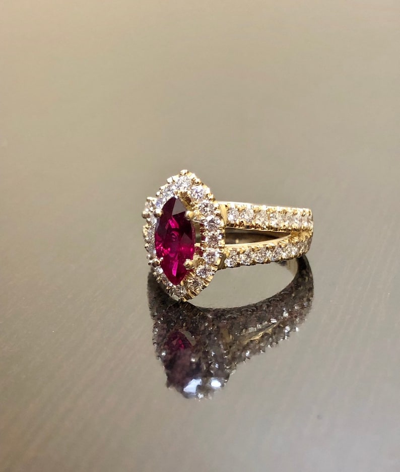 May include: A gold ring with a large, marquise-shaped ruby surrounded by a halo of smaller diamonds. The band is also set with diamonds.