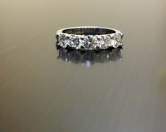 May include: A silver band with five round diamonds set in a row.
