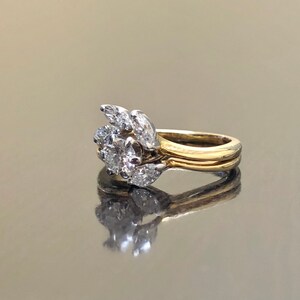 May include: A gold and white diamond engagement ring with a cluster of pear-shaped diamonds set in a delicate band.